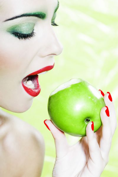 پرتره زن زیبا با آرایش رنگارنگ و سیب نگهدارنده پس زمینه