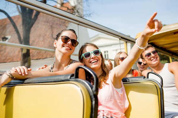 دوستی مسافرت تعطیلات تابستان و مفهوم مردم گروهی از دوستان لبخند که با اتوبوس تور مسافرت می کنند