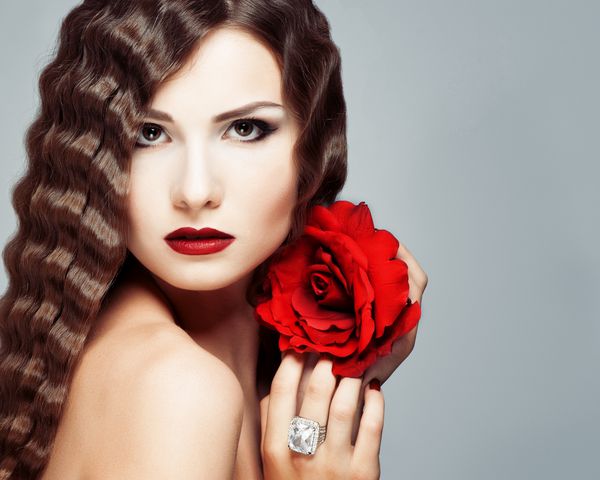 مدل جوان زیبا با لبهای قرمز و گل رز قرمز