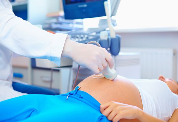 پزشک که روش سونوگرافی را برای خانم باردار انجام می دهد