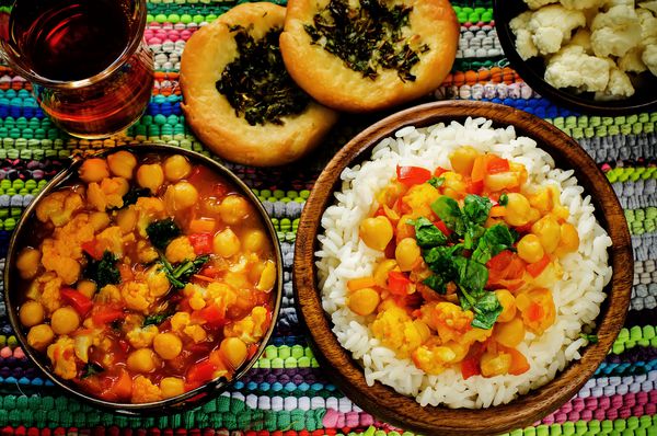 برنج با نخود فرنگی با سبزیجات و نان مسطح عربی با گیاهان با زمینه چند رنگ رنگ آمیزی تمرکز انتخابی در وسط برنج