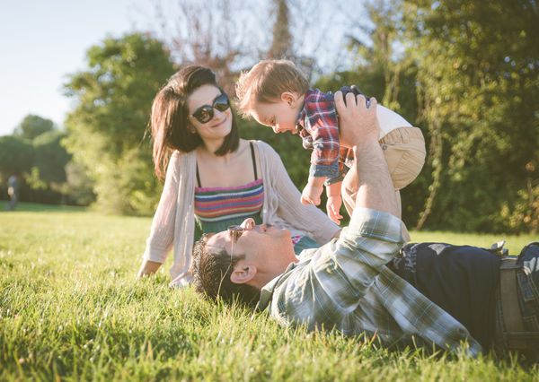 پرتره خانواده مبارک والدین جوان در یک پارک با بچه یک ساله خود