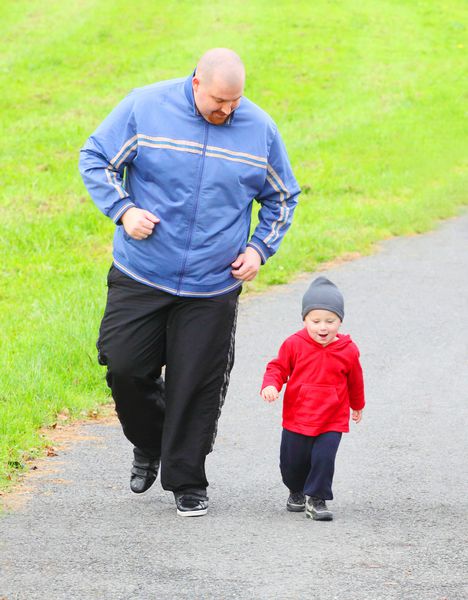 پدر اضافه وزن با پسرش که در حال دویدن هستند
