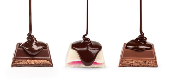 شکلات تیره بر روی یک تکه شکلات سفید با چاشنی صورتی پر شده روی آن ریخته می شود