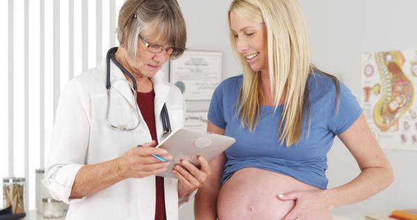 پزشک با قرص با زن باردار صحبت می کند