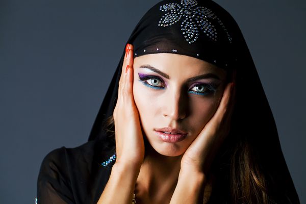 زن جوان و جوان زیبا با عربی سیاه و سفید در زمینه خاکستری