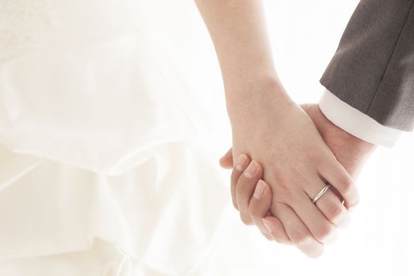 زن و شوهر جوانی که دست در دست دارند روز عروسی مراسم