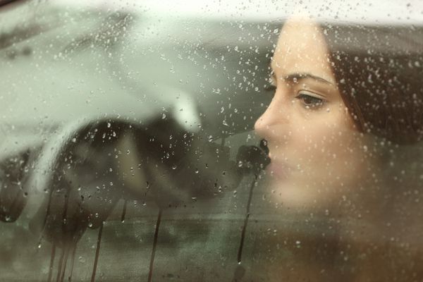 زن یا دختر نوجوان غمگینی که از یک پنجره ماشین بخار در حال جستجو است
