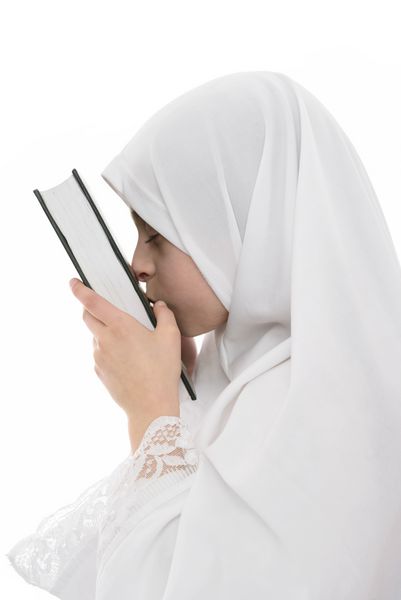 دختر جوان مسلمان عاشق کتاب مقدس قرآن است که در پس زمینه سفید جدا شده است