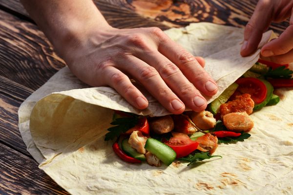 دستان مردان amp amp؛ x27؛ بسته بندی سنتی shawarma با مرغ و سبزیجات