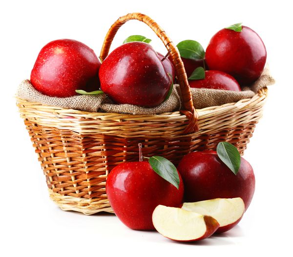 سیب های قرمز موجود در سبد حصیری روی سفید جدا می شوند