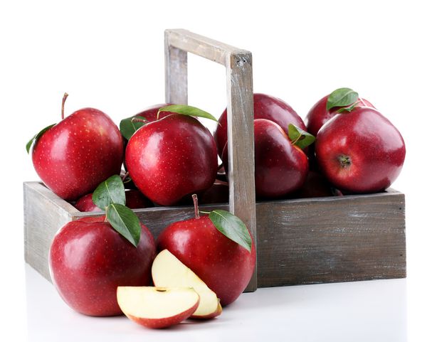 سیب های قرمز در جعبه چوبی بر روی رنگ سفید جدا می شوند
