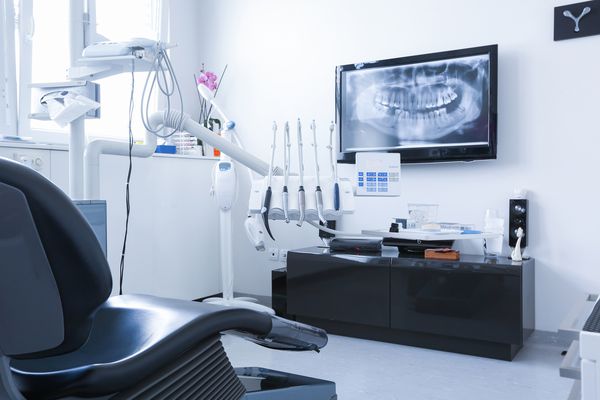 صندلی دندانپزشکان و ابزارهایی با تصویر اشعه ایکس در تلویزیون در پس زمینه مراقبت از دندان بهداشت دندان معاینه و معاینه درمانی