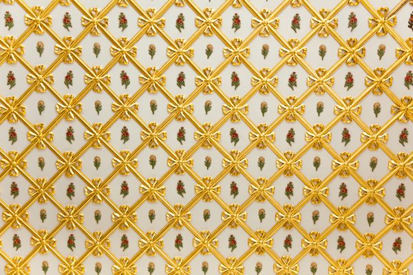 الگوی طلایی قدیمی هندسی و تزئینات گلها بر روی رنگ سفید بیش از 200 سال قدمت
