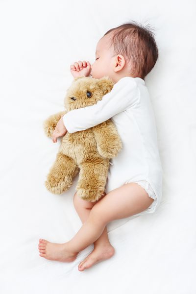 بهترین دوست من کودک که با خرس عروسکی خود خانواده جدید و مفهوم محافظت از کودک در خواب است