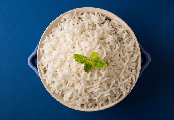 برنج سفید هندی باسماتی پخته یا بخارپز شده در یک کاسه سرامیکی روستایی با تمرکز انتخابی