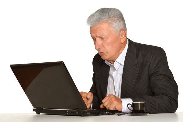 تاجر بالغی که با لپ تاپ روی زمینه سفید کار می کند