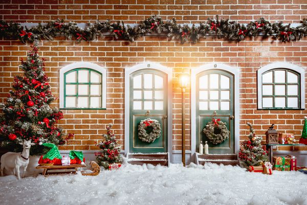 تزئینات داخلی استودیوی کریسمس با دو درب چوبی چراغ خیابان درخت کریسمس هدایا دیوار آجری و پنجره