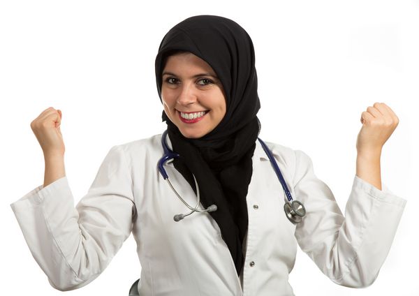 پرتره نزدیک از پزشک زن مسلمان دوستانه و لبخند با اعتماد به نفس که موفقیت را جشن می گیرد متخصص بهداشت و درمان جدا شده در زمینه سفید