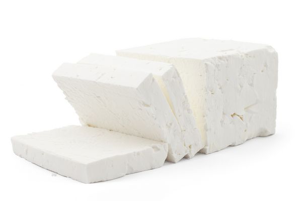 پنیر سفید تازه را از شیر گاو amp x27؛ s در زمینه سفید خرد کنید