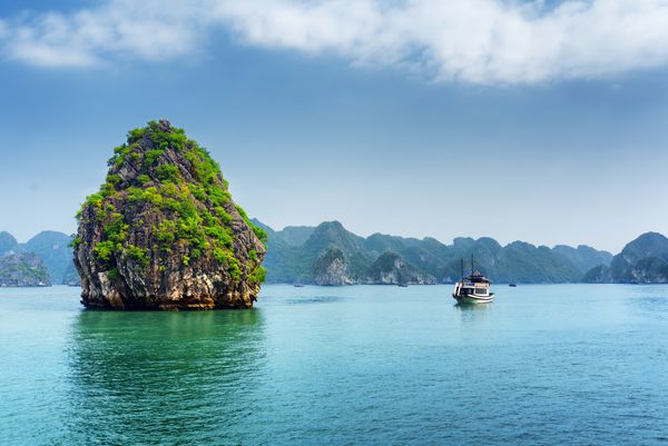 جزیره کارست منظره ای و قایق توریستی در خلیج Ha Long خلیج اژدها در خلیج Tonkin دریای چین جنوبی ویتنام خلیج هالونگ یک مکان توریستی محبوب آسیا است