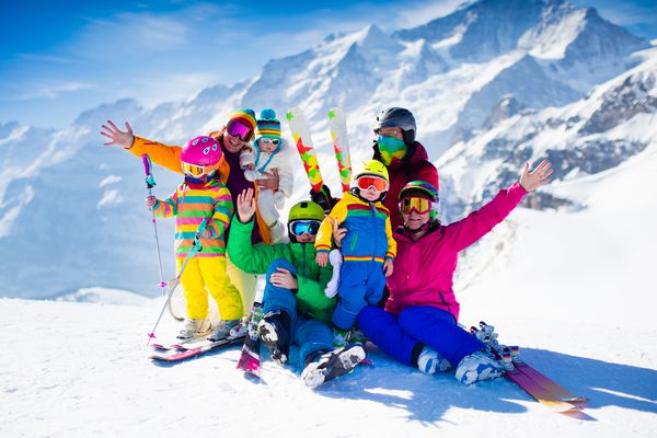 تعطیلات اسکی خانوادگی گروه اسکی بازان در کوه های آلپ سوئیس بزرگسالان و کودکان خردسال نوجوان و اسکی کودک در زمستان والدین به بچه ها اسکی را در کوهنوردی در کوه های سراشیبی می آموزند پوشاک و پوشاک اسکی کلاه ایمنی