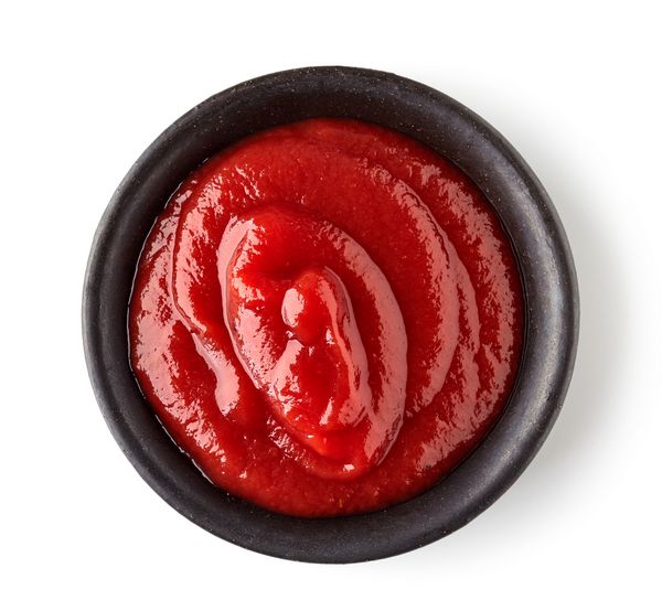 کاسه سس گوجه فرنگی یا سس گوجه فرنگی جدا شده در پس زمینه سفید نمای بالا