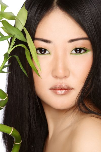 پرتره کلوزآپ دختر زیبا و جوان آسیایی با بامبو سبز