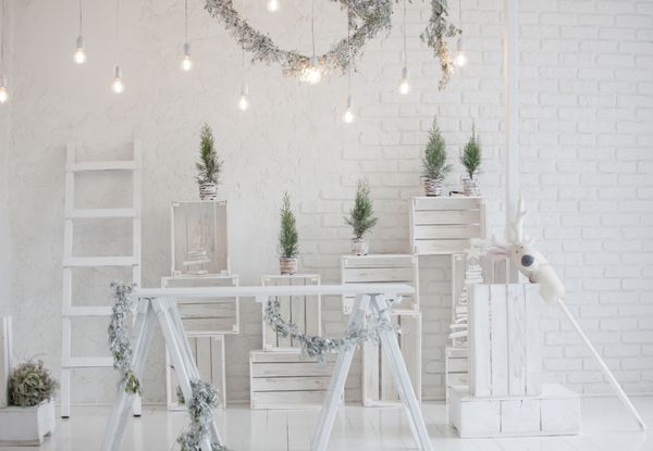 کریسمس مبارک و پس زمینه دیوار آجری سال نو تزئینات سفید با درختان و چراغهای صنوبر