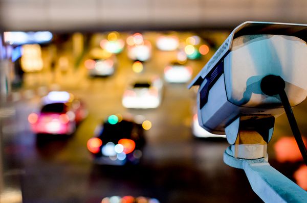 یک دوربین مدار بسته امنیتی امنیتی با استفاده از ترافیک در شهر شب در بانکوک تایلند ماشین زیادی را در جاده متمرکز و ضبط کرده است