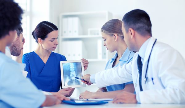 حرفه افراد جراحی رادیولوژی و مفهوم دارو گروه پزشکان دارای اشعه ایکس در صفحه نمایش رایانه لوحی رایانه در مطب