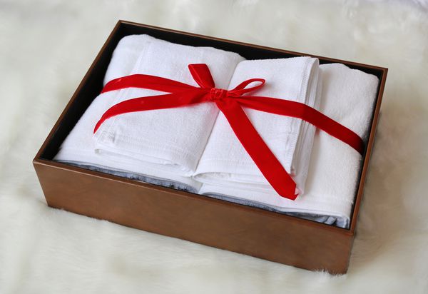 هدایای حوله سفید در جعبه چرمی در زمینه خز مصنوعی