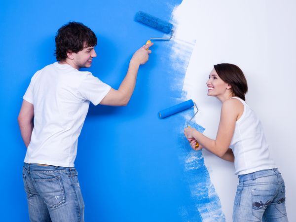 نوسازی با خندیدن زوج دوست داشتنی شاد که دیوار را مسواک می زند
