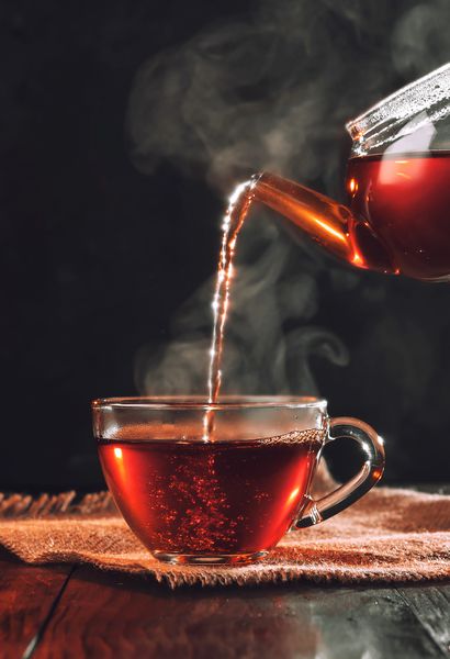 فرآیند دم کردن چای مراسم چای فنجان چای تازه دم کرده سیاه نور نرم و گرم زمینه تیره تر