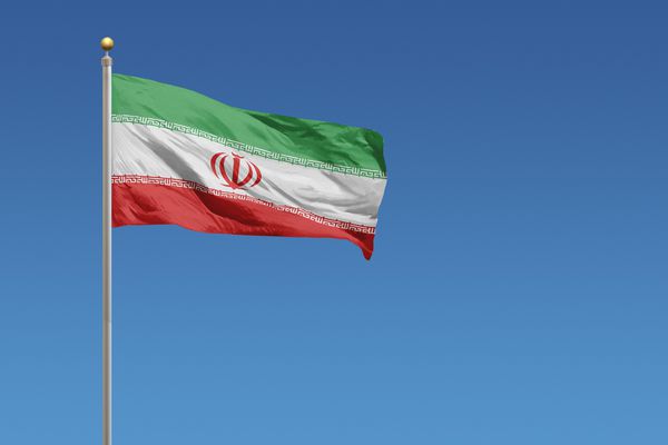 پرچم ایران در مقابل یک آسمان آبی روشن