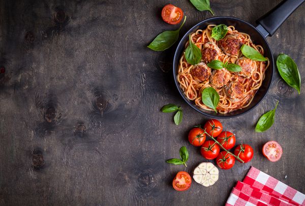 اسپاگتی با کباب سس گوجه فرنگی زمینه ظرف ایتالیایی آمریکایی ماکارونی کباب در یک قابلمه فضای متن در بالای سر غذاهای سنتی ایتالیایی میز چوبی روستایی تیره شام با ماکارونی