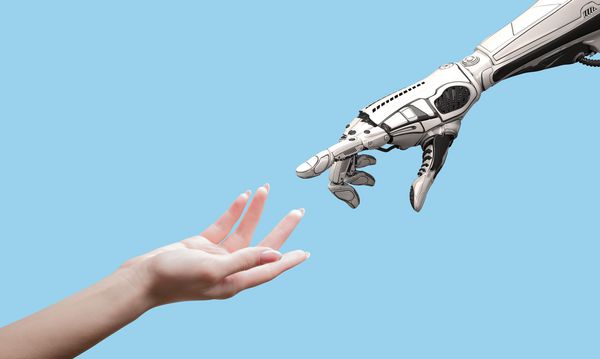دست و ربات زنانه زن و به عنوان نمادی از ارتباط بین افراد و فناوری هوش مصنوعی که برای طراحی به رنگ آبی جدا شده است