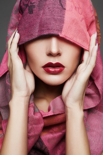 زن زیبا صورت خود را با یک پارچه رنگی پوشانده شده است لبهای رنگی دخترانه زن شیک مد اسلامی به رنگ صورتی