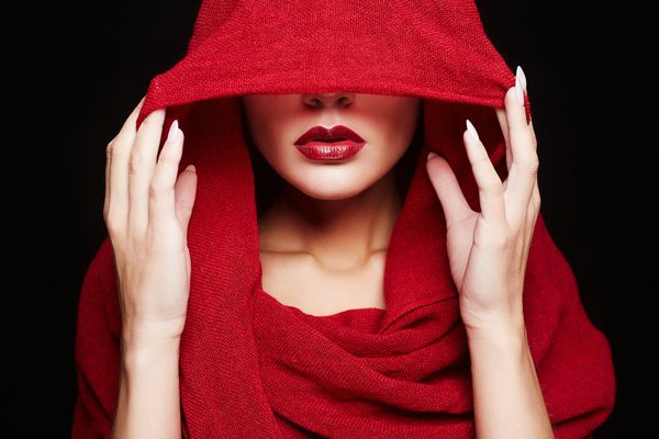 زن زیبا صورت خود را با پارچه قرمز پوشانده است لبهای قرمز در زیر هودفروش زن سبک اسلامی