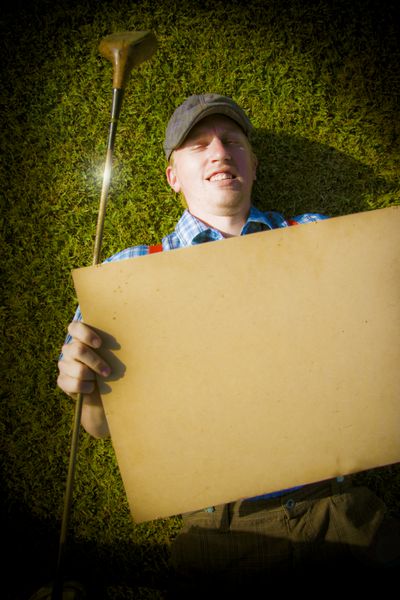 مرد گلپر در حالی که بیلبورد یا یادداشتی در پیام ورزشی دارد تصویر با کپی برداری را در کنار گیاه گلف خود قرار می دهد