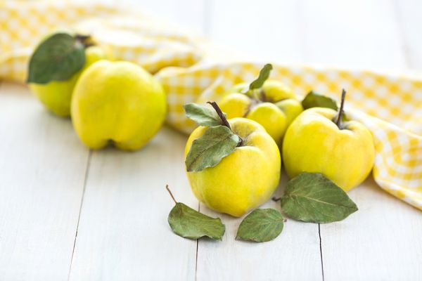 سبک زندگی سالم تغذیه مفهوم پاییز روی میز سفید میوه های زرد بسیار روشن وجود دارد که بنام آنها بسیار سالم است و حاوی ویتامین های زیادی است