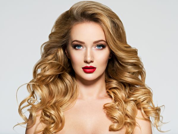 پرتره زن با موهای بلند و لبهای قرمز مدل مد با آرایش روشن