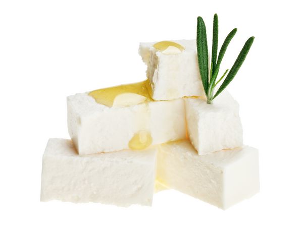مکعب های پنیر فتا با شاخه رزماری و قطره های روغن جدا شده روی سفید