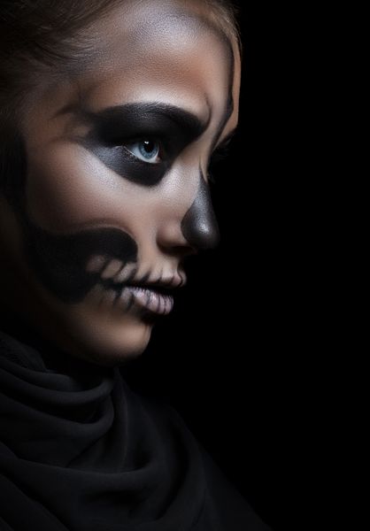 نمای نزدیک از یک دختر با اسکلت آرایش پرتره هالووین جداسازی بر روی زمینه سیاه