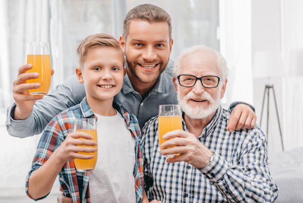 پدر پسر و پدربزرگ لیوان آب پرتقال را در دست داشتند لبخند می زدند و به دوربین نگاه می کردند