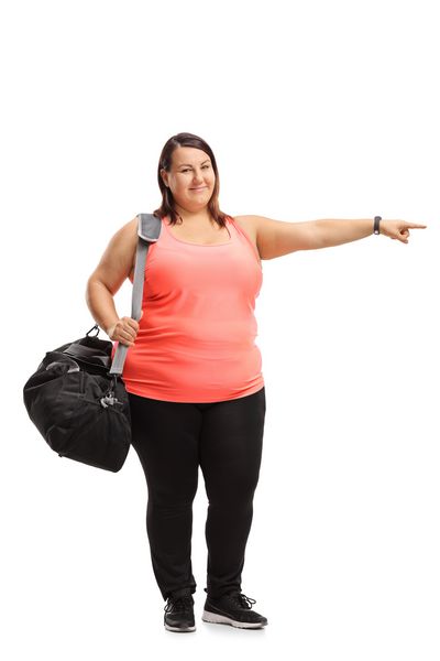 پرتره کامل یک دختر اضافه وزن با یک کیسه ورزشی که به صورت جدا شده در پس زمینه سفید نشان داده شده است
