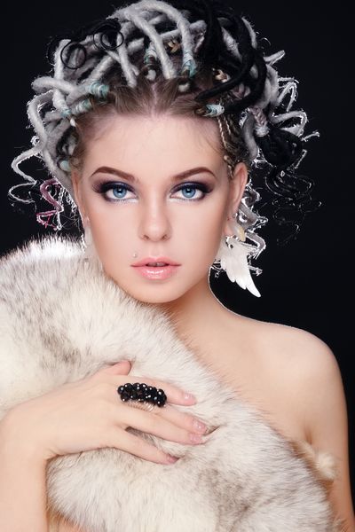 دختر جوان زیبا با مدل موهای فانتزی از ترس و خز سفید روی بدن