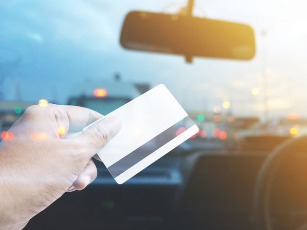 کارت اعتباری در دست گرفتن بیش از پیش زمینه تاری کابین خلبان اتومبیل در ایستگاه عوارض پرداخت در تردد تردد شب