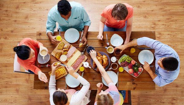 مفهوم غذا غذا و خانواده گروهی از افرادی که صبحانه می خورند و سر میز می نشینند