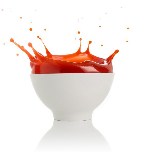 سوپ گوجه فرنگی که از یک کاسه جدا شده روی سفید جدا شده است